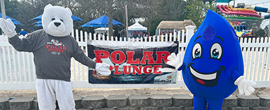 Blue drop mascot in front of military truck